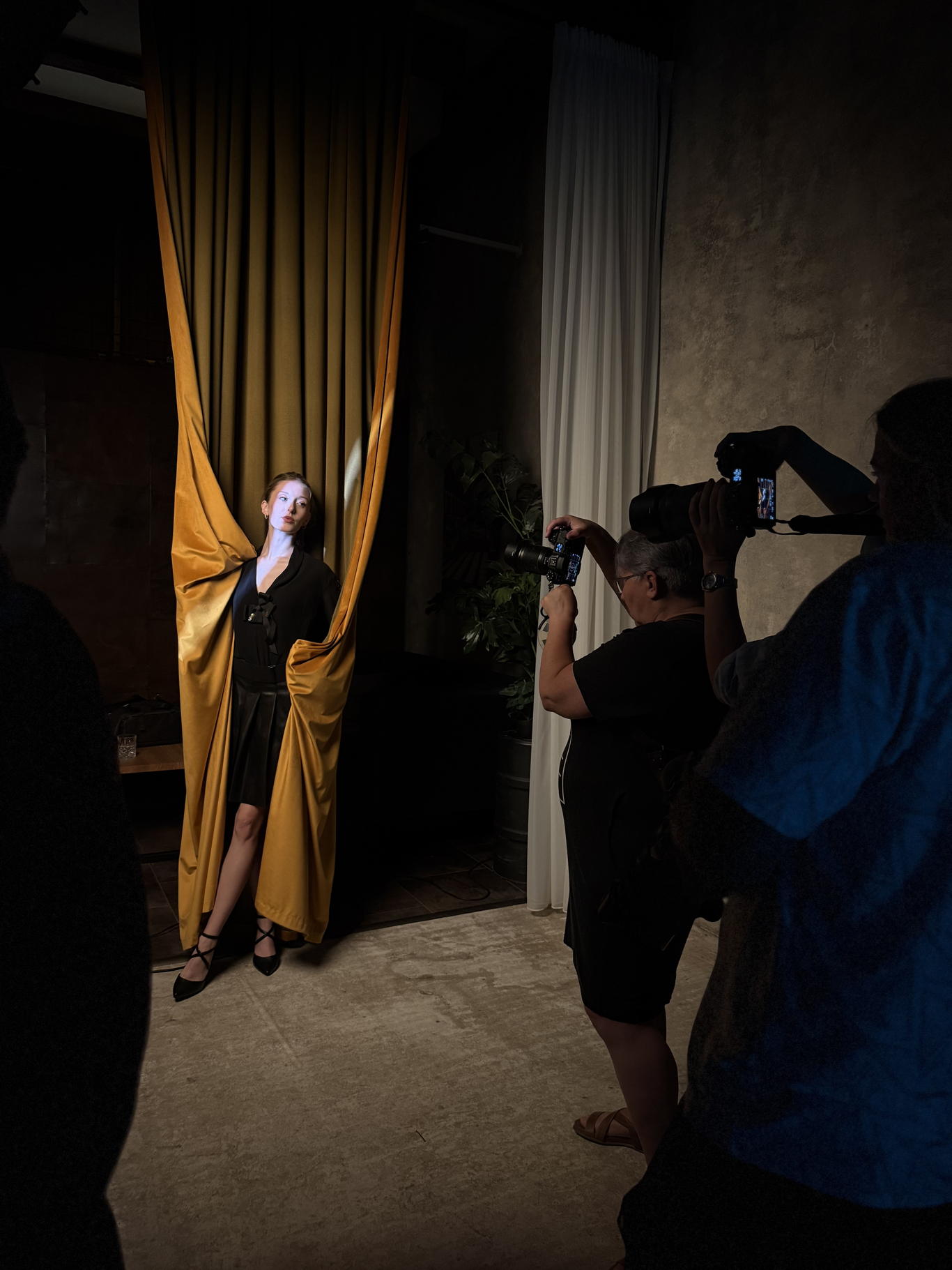 Curtain Space při workshopu portrétového svícení — modelka ve zlatém sametovém závěsu a fotografka s foťákem