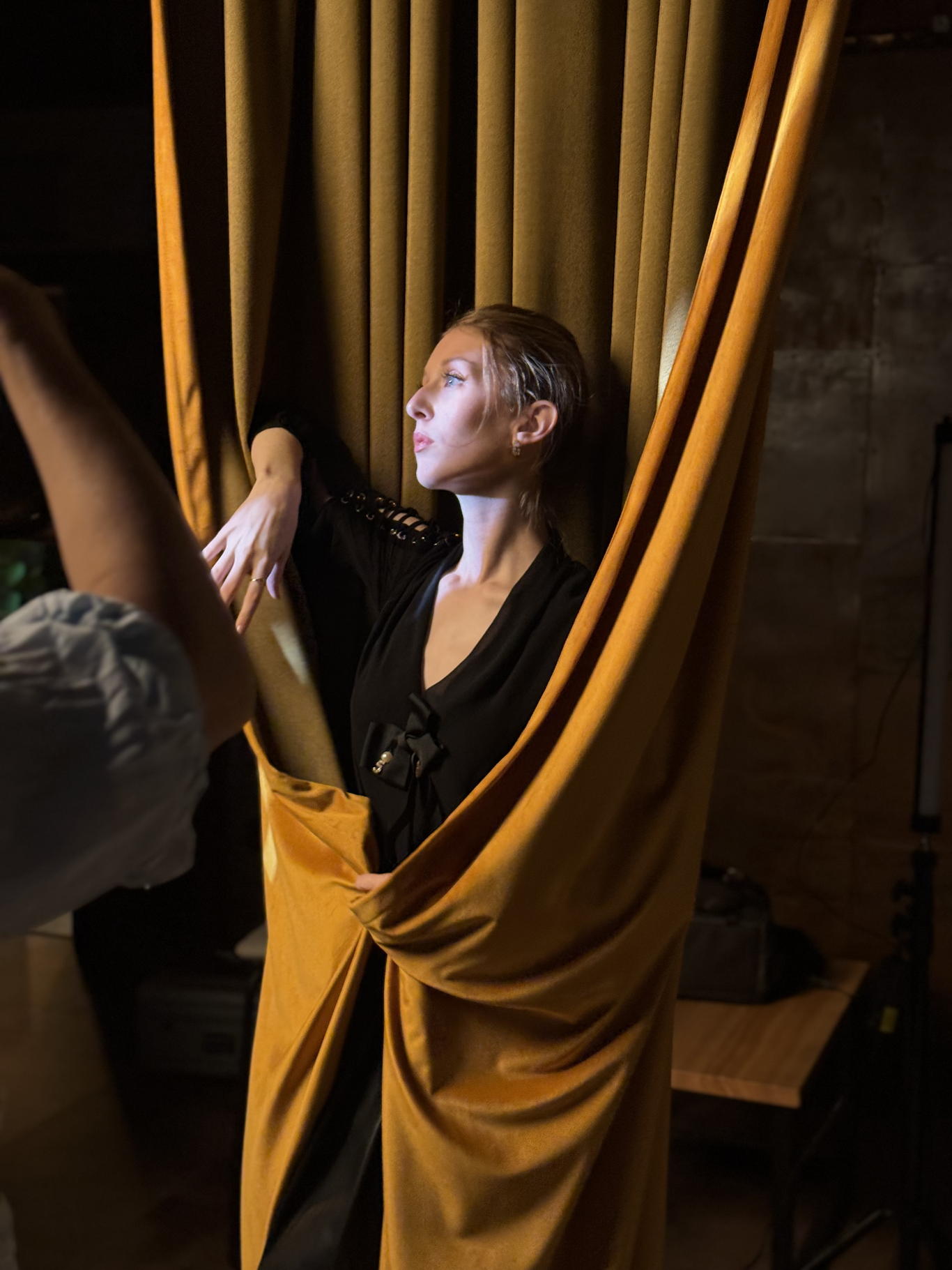 Detail z Curtain Space — profil modelky ve zlatém sametu, boční světlo