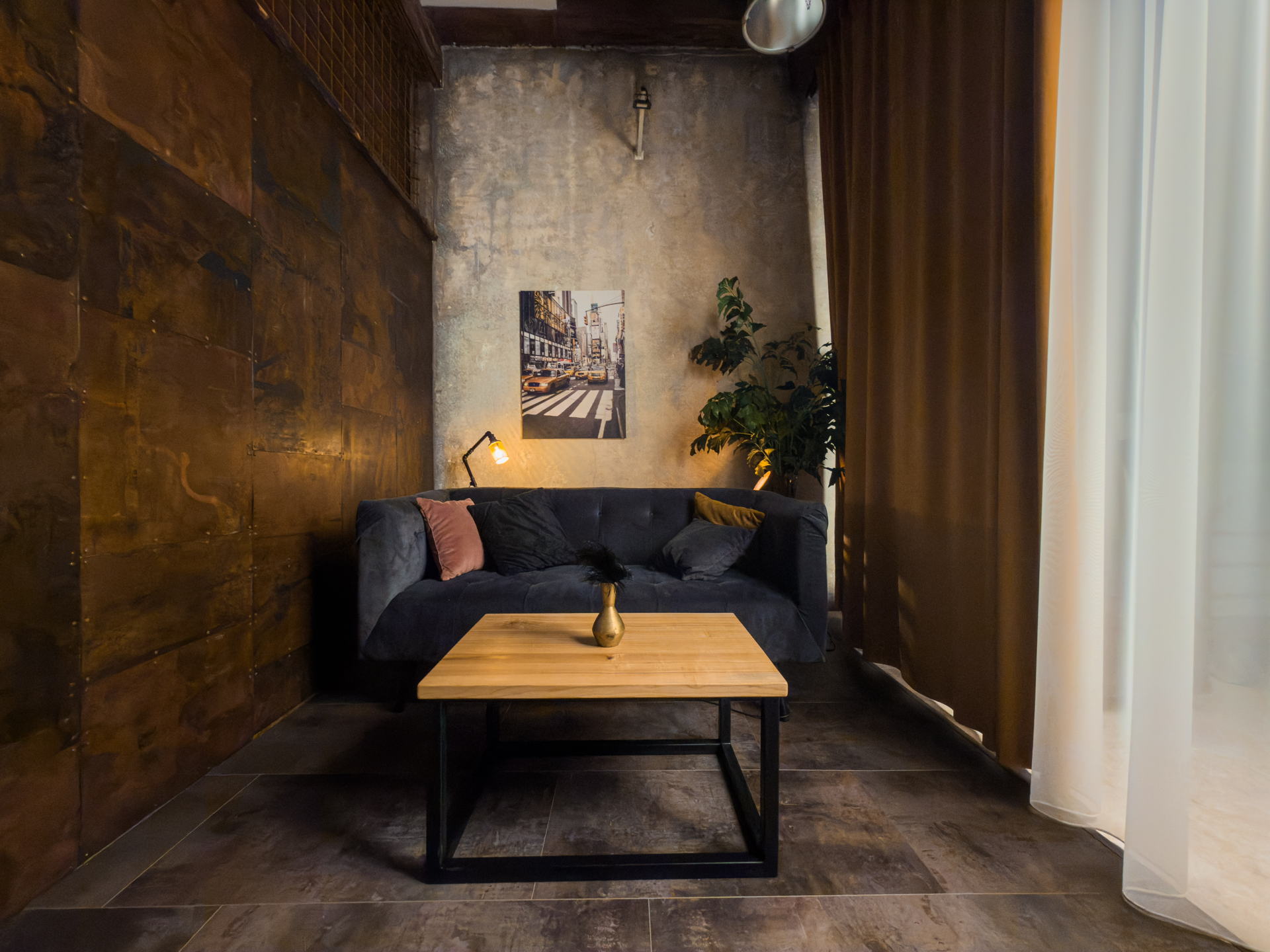 Scéna Urban Chic — pohled od rezavého plechu na gauč a obraz newyorské ulice
