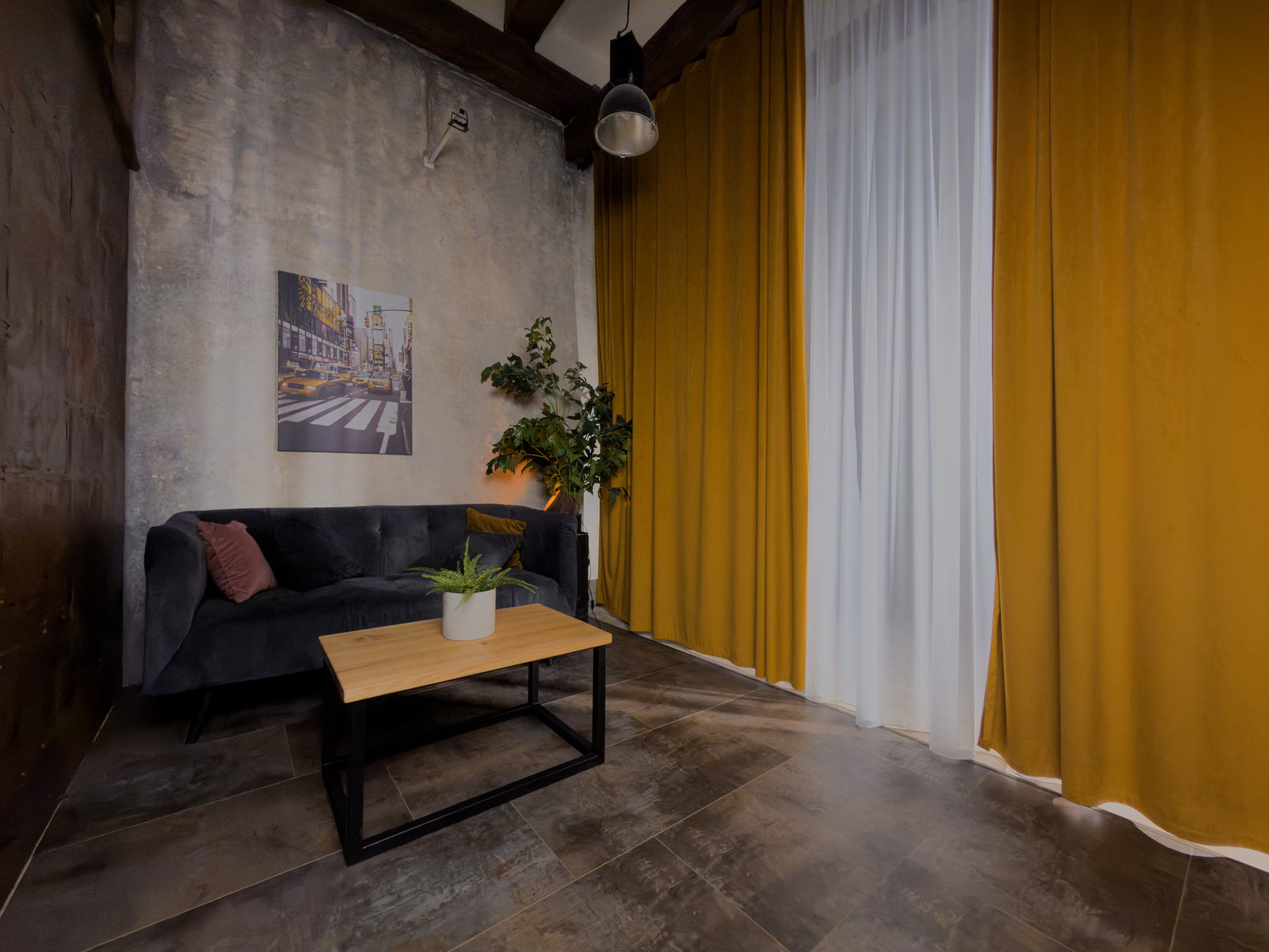 Celkový pohled na scénu Urban Chic — patinovaná stěna, obraz newyorské ulice, gauč a hořčicové závěsy